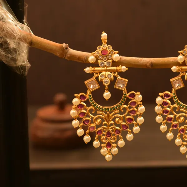Gold-tone chandbali earrings with ruby stones and a pearl fringe