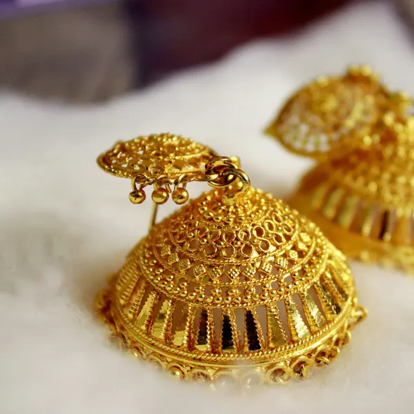 A pair of gold jhumka earrings